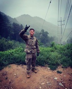 Male in military uniform in green area