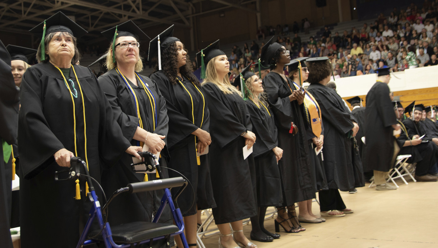 The graduates standing during commencement